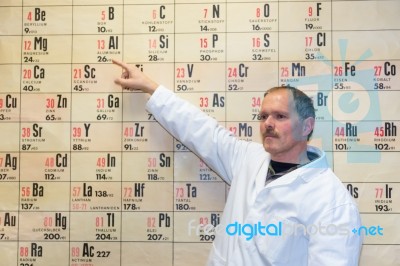 Chemistry Teacher Pointing At Periodic Table Stock Photo