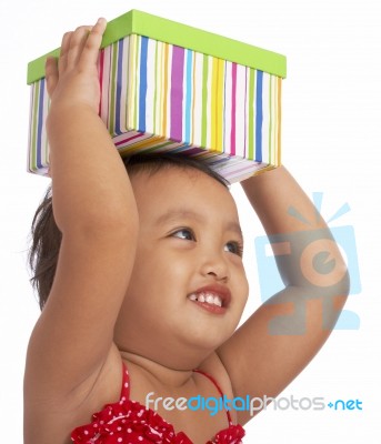 Child Holding Gift On Her Head Stock Photo