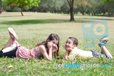 Children Lie Down On Grass Stock Photo