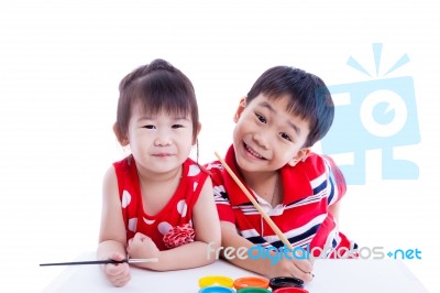 Children Looking At The Camera And Smiling, Holding A Paintbrush… Stock Photo