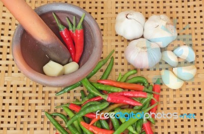 Chili And Garlic In Mortar On Wooden Textured Stock Photo