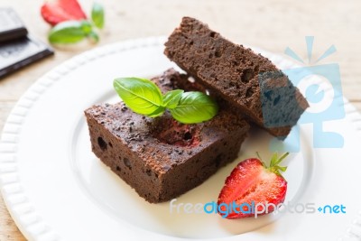 Chocolate Brownie Cake On White Plate Decorated With Strawberrie… Stock Photo