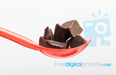 Chocolate On Red Spoon Stock Photo