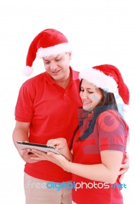 Christmas Couple Looking A Tablet Computer Stock Photo