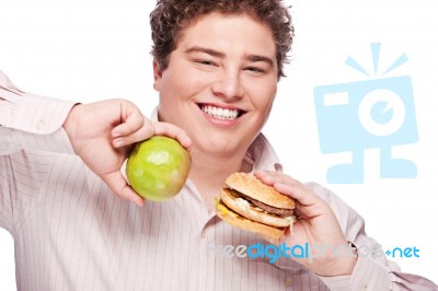 Chubby Man Holding Apple And Hamburger Stock Photo