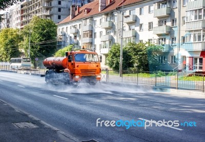 Cleaning Machine Washing The City Asphalt Road With Water Spray Stock Photo