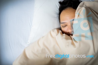 Close Up Of An Asian Man Face Sleeping On White Bed, Top View Stock Photo