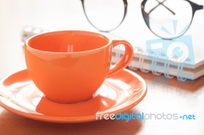 Close Up Of Coffee Cup With Book And Eyeglasses Stock Photo