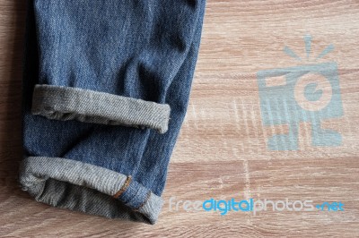 Close Up Of Fold Selvedge Denim Jeans On Wooden Background With Stock Photo