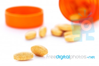 Closeup Of Orange Pills And Pill Bottle Stock Photo