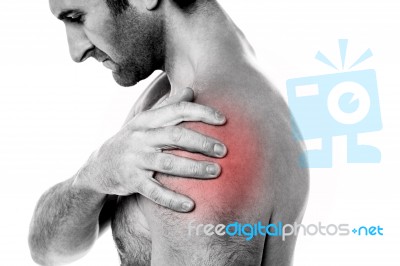 Closeup Of Young Man Having Pain In Shoulder Stock Photo