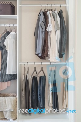 Clothes Hanging In White Wardrobe Stock Photo
