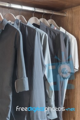 Clothes Hanging In Wooden Wardrobe Stock Photo Clothes Hanging In Wooden Wardrobe Stock Photo