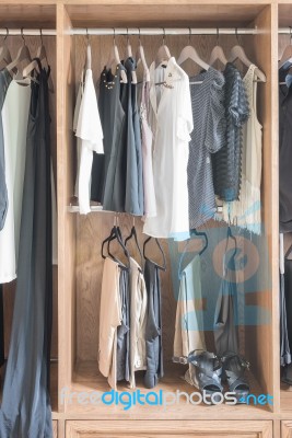 Clothes Hanging In Wooden Wardrobe Stock Photo