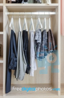 Clothes Hanging In Wooden Wardrobe Stock Photo