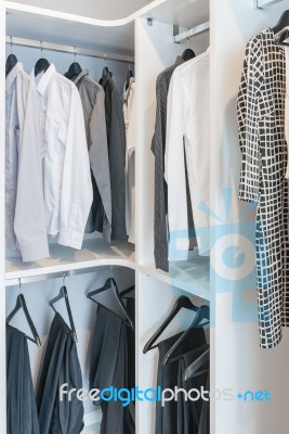 Clothes Hanging On Rail In White Wardrobe Stock Photo