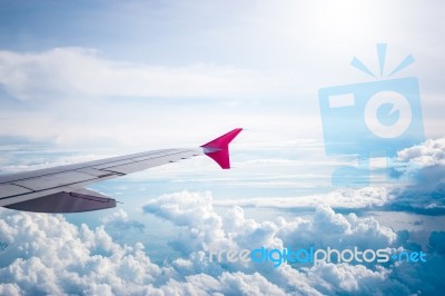 Cloudy Sky And Red Airplane Wing As Seen Through Window On Aircr… Stock Photo
