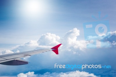 Cloudy Sky And Red Airplane Wing As Seen Through Window On Aircr… Stock Photo