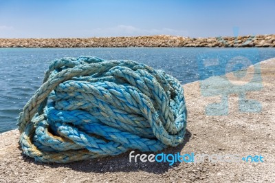 Coiled Blue Mooring Rope At Water In Greek Cave Stock Photo