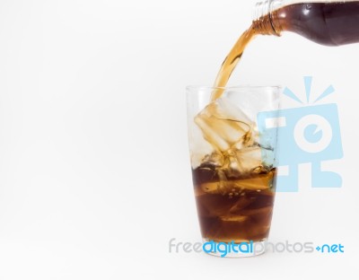 Cola Pouring From A Plastic Bottle Into A Glass Filled With Ice Cubes Stock Photo