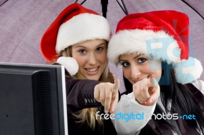 Colleagues Wearing Christmas Hat And Pointing Towards Stock Photo