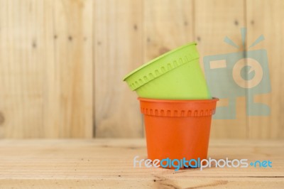 Color Plastic Pot On Wood Background Stock Photo
