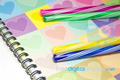 Colorful Heart Graphic Cover Notebook, Diary With Colorful Pen Stock Photo