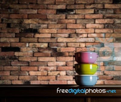 Colorful Tiffin Carrier On Wooden Cupboard Stock Photo