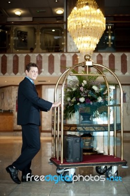 Concierge Pushing The Luggage Cart Stock Photo