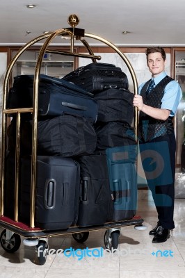 Concierge With Pile Of Bags In Cart Stock Photo