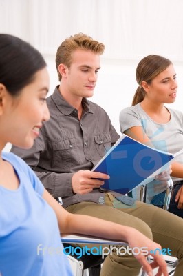 Confident Businessman Sitting With His Colleagues In Office Stock Photo Confident Businessman Sitting With His Colleagues In Office Stock Photo