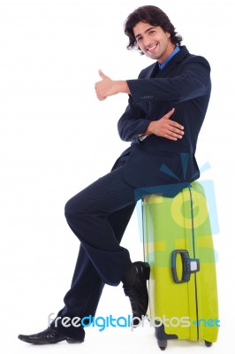 Corporate Man Sitting On Luggage Showing Thumbsup Stock Photo