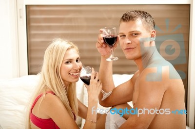 Couple Drinking On The Bed Stock Photo
