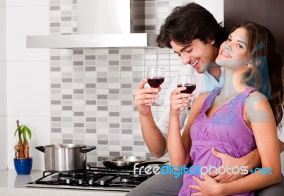 Couple Drinking Wine In Their Kitchen Stock Photo