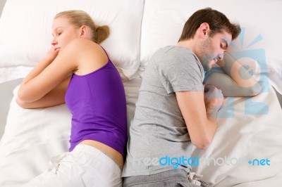 Couple Lying In Bed Back-to-back Stock Photo