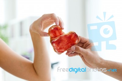 Couple Making Heart Sign With Two Slices Of Bread With Jam Stock Photo