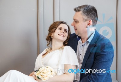 Couple Of Newlyweds Are Sitting Together Looking At Each Other Stock Photo