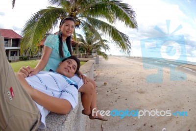 Couple Relaxing At Beach Stock Photo