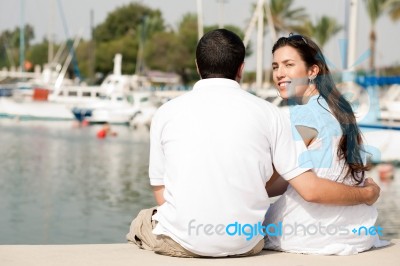 Couple Sitting At The Harbour Stock Photo