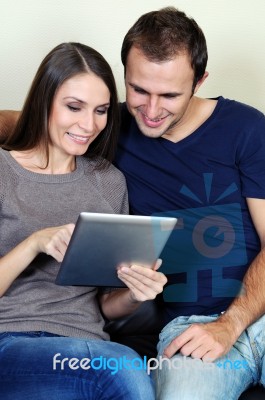 Couple Using A Tablet Computer In Their Living Room Stock Photo