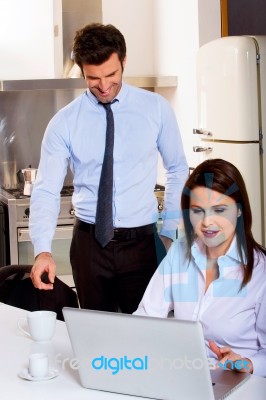 Couple With Computer In Kitchen Stock Photo