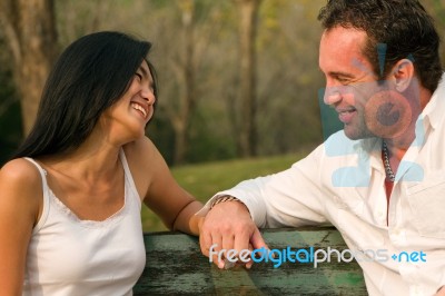 Couples Sat Hand In Hand And Smile Stock Photo