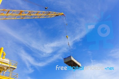 Crane Boom While Lifting Basket In The Sea Stock Photo