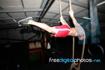 Crossfit Rope Climb Training On A Dark Background Stock Photo