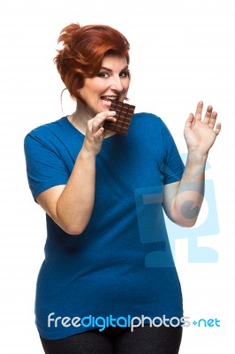 Curvy Woman Eating Chocolate Stock Photo