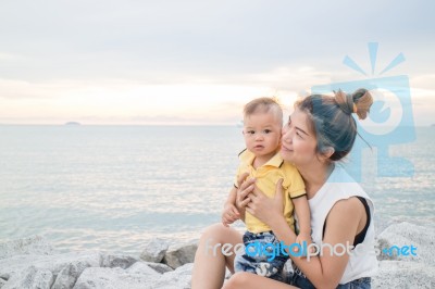 Cute Boy Pose On The Beach With His Mother Stock Photo