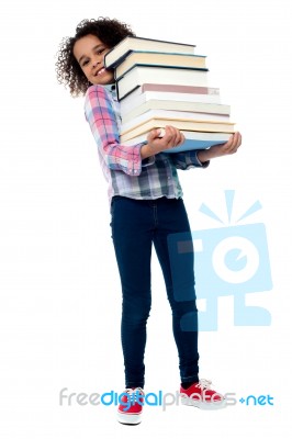 Cute Cheerful Child Carrying Stack Of Books Stock Photo