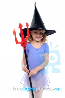 Cute Girl Holding Trident And Wearing Witches Hat Stock Photo