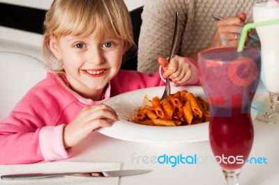 Cute Kid Enjoying Pasta And Watermelon Juice Stock Photo