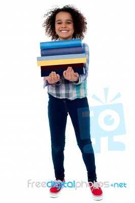 Cute Little Girl Carrying Stack Of Books Stock Photo